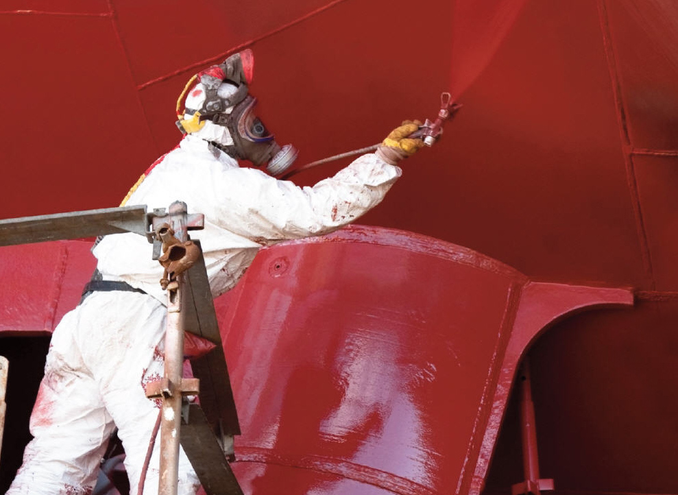 Man spraying paint on a ship